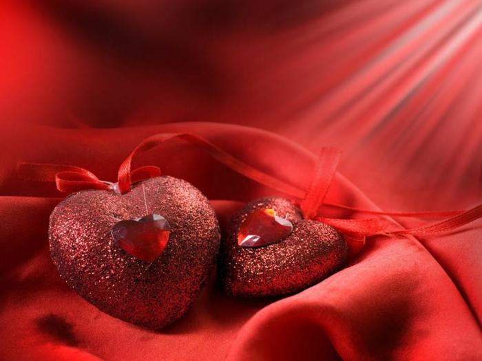 Valentinstagsgrüße - zwei Herzen mit Glasperlen Herzen verziert auf rotem Hintergrund