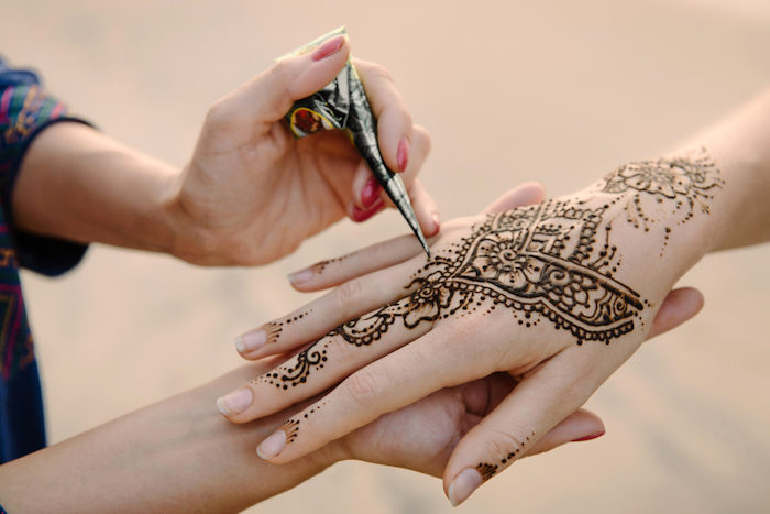 henna tattoo selber machen, temporäre tätowierung mit braunem henna am hand, hände verzieren