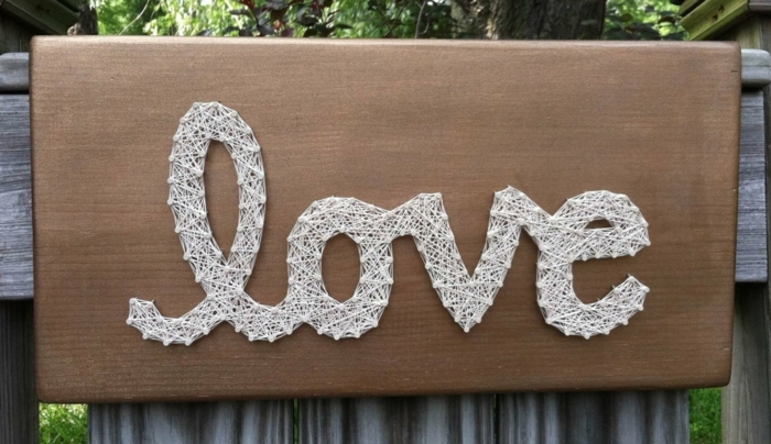 das Wort Liebe auf Englisch an einer Tabelle geschrieben, String Art Vorlage