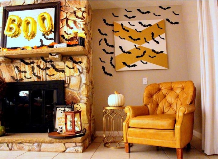 ein wohnzimmer mit einem großen gelben sessen, eine dekoration mit einem kleinen weißen kürbis, ein wand mit vielen kleinen schwarzen fledermäusen aus papier und mit schwarzen flügeln und schwarzen ohren, eine fledermaus malen