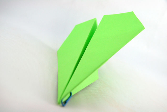 weißer tisch und ein kleiner grüner papierflieger, bastelideen mit papier, bester papierflieger der welt