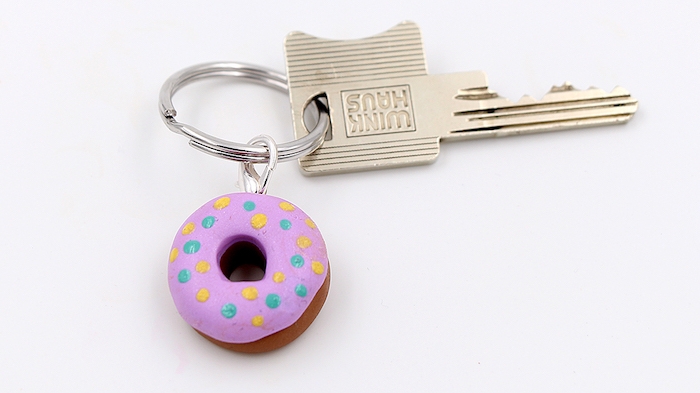 kleiner schlüsselanhänger mit einem kleinen pinken donut aus einer fimo knete, schlüssel aus metall, fimo ideen