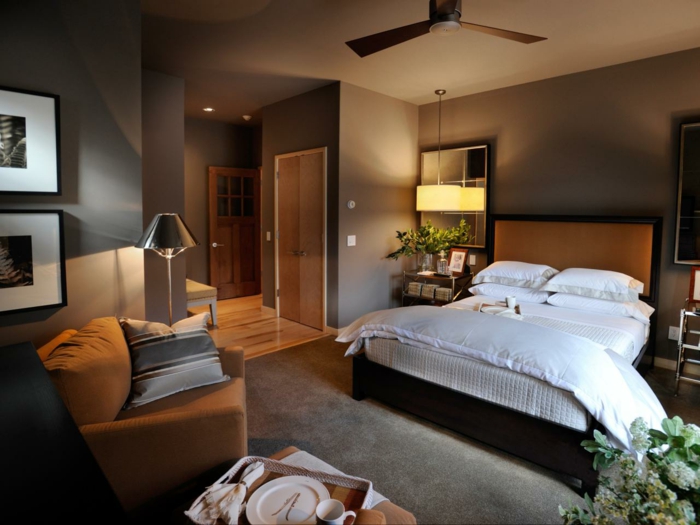 moderne Zimmer mit einem großen Bett und Leseecke, grauer Teppich, Pflanzen als Dekoration