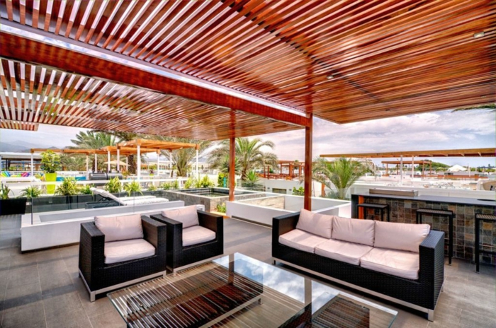 Terrassenüberdachung aus Bambus, modene Terrasse mit zwei Sessel und ein Sofa, Tisch mit gläsernem Oberteil