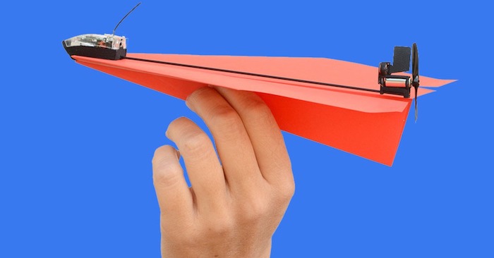 ein blauer himmel und eine hand mit einem kleinen roten papierflieger, einen papierflieger bauen