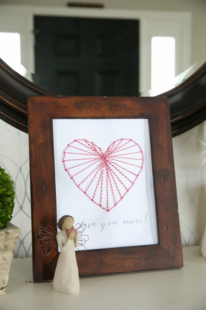 eine romantische Deko mit Nagelbilder von Herz mit roten und weißen Fäden