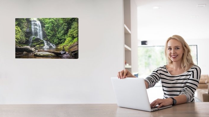 eine junge frau und ein leinwandbild mit einem wasserfall 