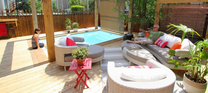 Sichtschutz aus Holz, ein Schwimmbad und Loungemöbel, kleiner Tisch, Terrasse gestalten