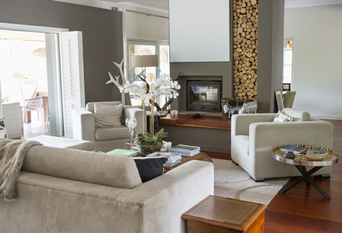 Wohnwand mit Holzoptik, graue Sessel, ein Kamin, selber bauen Ideen für Wohnzimmer