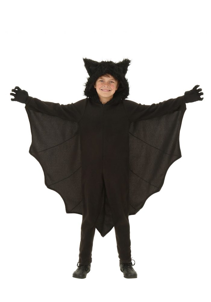 ein kind mit einem großen schwarzen fledermaus kostüm mit schwarzen flügeln und schwarzen ohren, ein fledermaus kostäm kinder. fledermaus häkeln