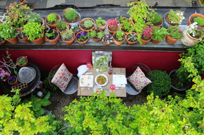 eine bunte Terrasse, zwei Stühle mit bunten Kissen dekoriert, Terrasse bepflanzen