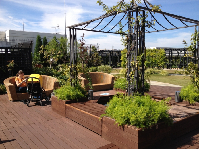 schwarze Pergola, zwei große Rattan Sessel, Terrasse bepflanzen mit viele grüne Pflanzen