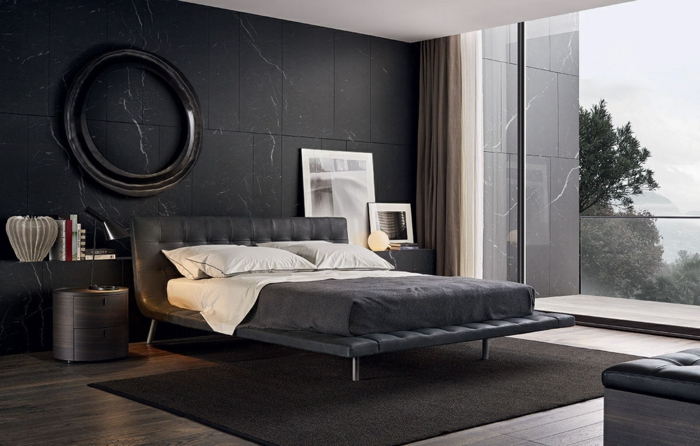 graue moderne Zimmer, graue Wände, gepolstertes Bett, graue Bettwäsche und runder Rahmen