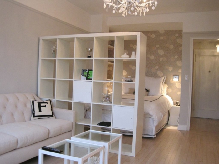 Ikea Raumteiler in weißer Farbe mit Aufbewahrungsraum, daran ein Sofa, dahinter ein Bett