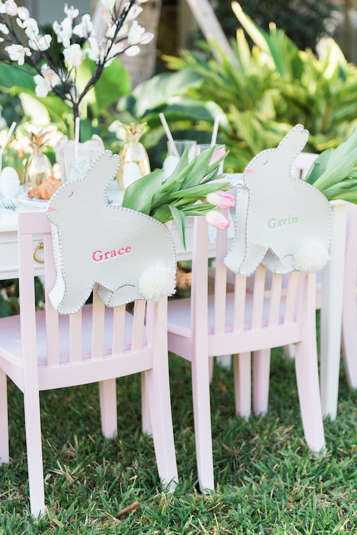 Ostertischdeko in zarten Farbnuancen, rosa Tulpen, weiße Osterhasen aus Leder, rosa Holzstühle, Osterparty im Garten