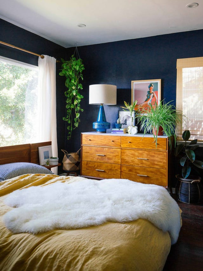 eine grüne Pflanze in der Ecke, ein Bett mit gelber Decke, Regal mit Zimmerpflanzen, moderne Zimmer