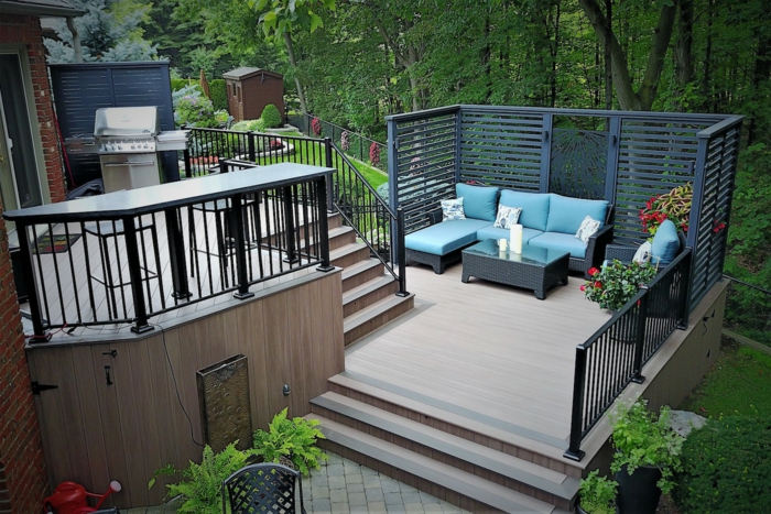 eine Terrasse auf zwei Etagen, blaue Loungemöbel mit weißen Kissen, Terrassen Gestaltungsmöglichkeiten