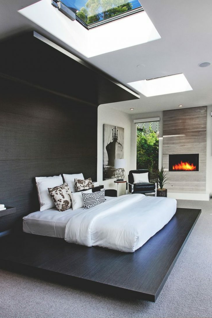 ein gemütliches Schlafzimmer mit Kamin, weiße Matratze und weiße Bettwäsche