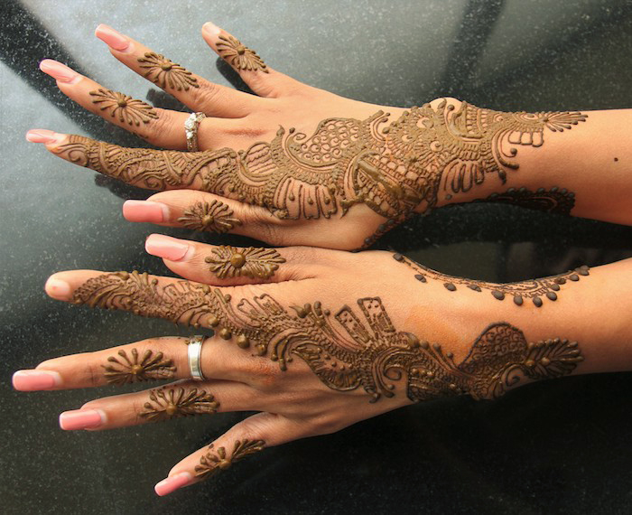 wie lange hält henna, frau mit sehr detallierten tätowierungen mit henna, mehndi, lange nägel