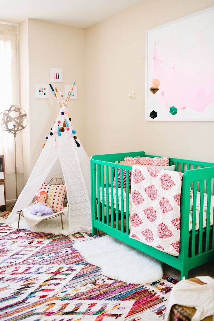 Babyzimmer Einrichtung, grünes Babybett aus Holz, weißer Zelt mit bunten Pompons verziert