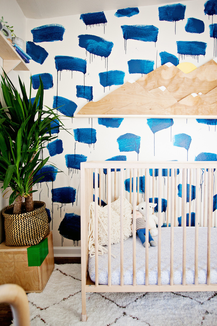 Babyzimmer im Vintage Stil, Babybett aus Holz, grüne Pflanze, Tupfetechnik an der Wand