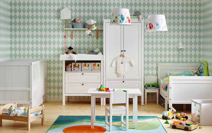 Babyzimmer in hellen Pastelnuancen, weiße Holzmöbel, Lampenschirme mit bunten lustigen Motiven. bunter Teppich, Bett für Kuscheltiere