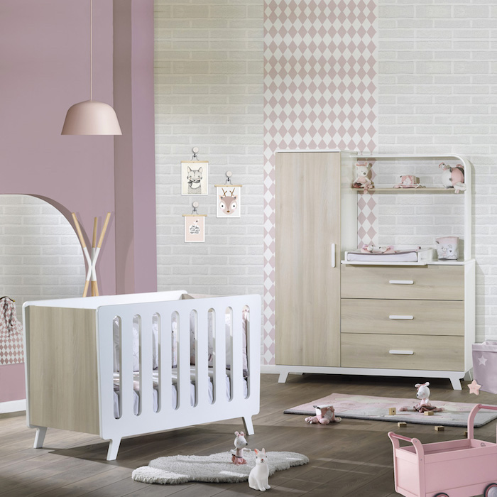 Mädchenzimmer in zarten Pastellnuancen, weißes Babybett aus Holz, kleine Kuscheltiere auf dem Boden