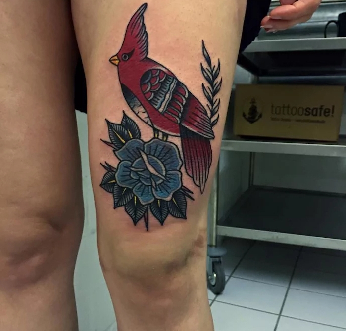 farbiges bein tattoo, roter vogel am blauer blume, frau mit großer tätowierung mit tier-motiv