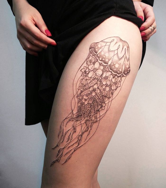bein tattoo in schwarz und grau, große tätowierung mit meduse als motiv, medusen tattoo, frau