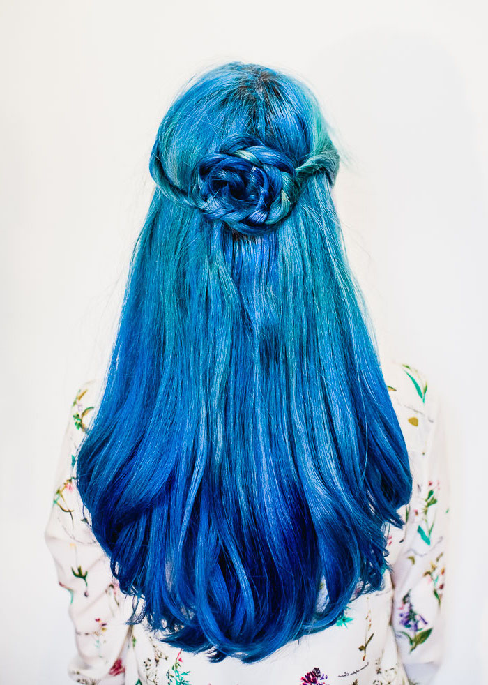Blaue Haare, Langhaarfrisur mit Haarblume, zwei Blaunuancen, weißes Hemd mit Blumenmuster