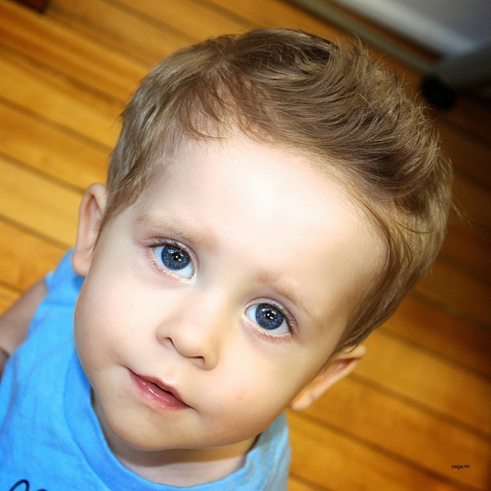 große blaue Augen, niedliches Baby mit einem von den klassischen Jungen Frisuren