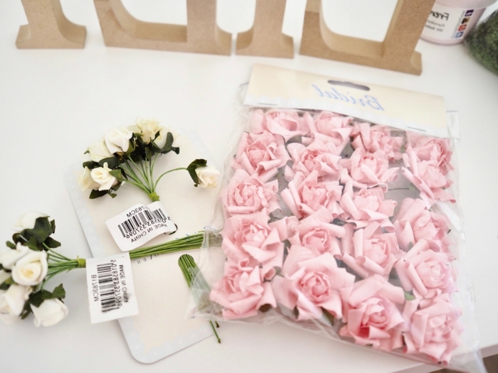 Materialien für DIY Kinderzimmer Buchstaben, kleine weiße und rosafarbene künstliche Rosen 
