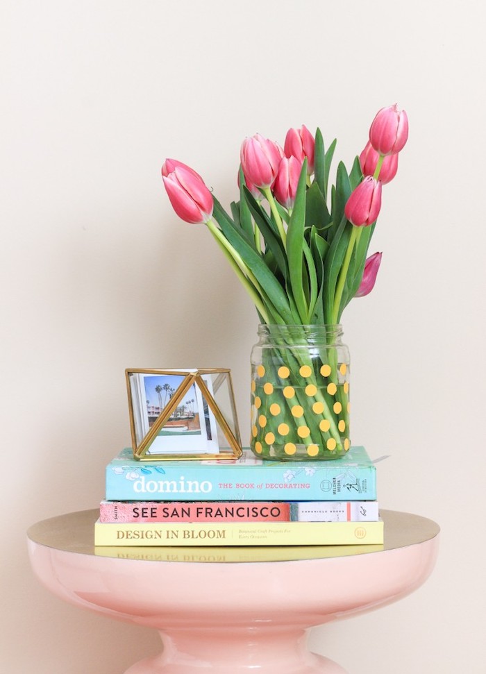 Tulpenstrauß in Einmachglas, gelbe Punkte, rosa Tisch, drei Bücher, kleine Fotos in Box