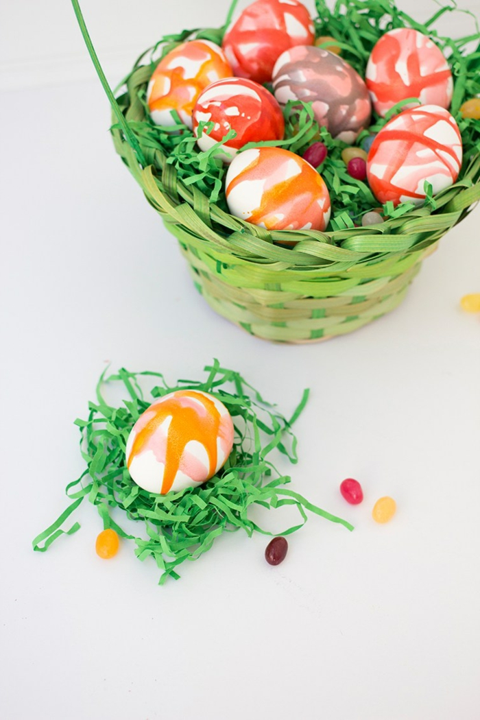 ein Nest mit künstlicher Gras und ein bemaltes Ei darin, Ostereier dekorieren