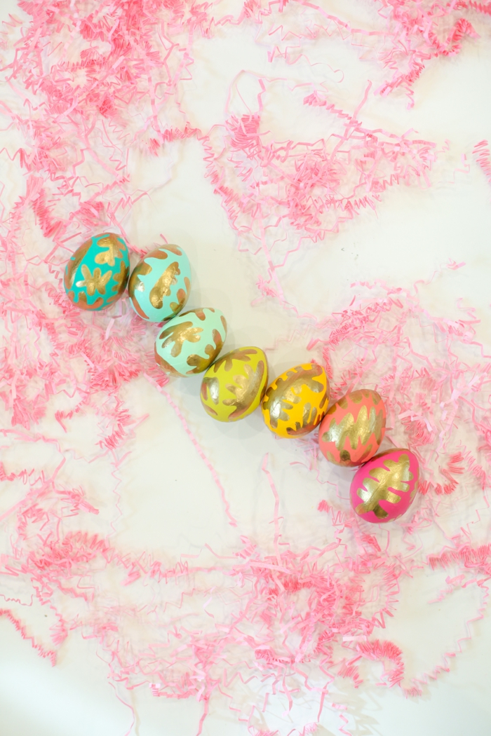 eine Reihen von bunten Eier, Ostereier dekorieren mit goldener Farbe wie Blätter