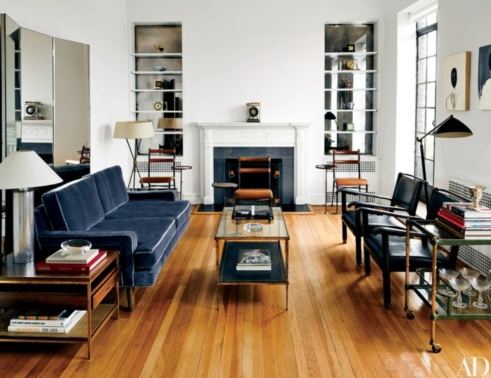 ein Kamin und Regale an der Wand, blaues Sofa und schwarze Stühle, kleine Räume einrichten