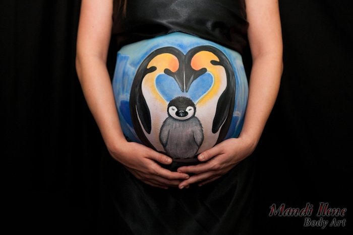 ein bild mit drei pinguinen und eis und einem blauen himmel, kleid für babybauch shooting, eine schwangere frau mit einem großen bemalten babybauch