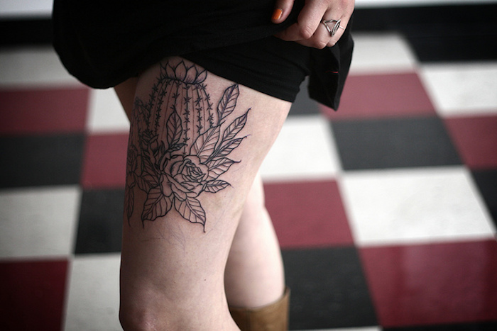 frisches tattoo mit blumen-motiv, bein tätowieren, schwarzes kleid, tattoo-motive für frauen