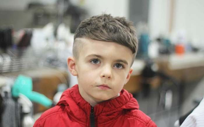 ein kleiner Junge mit roter Jacke, Undercut Frisur, coole Frisuren für Kinder