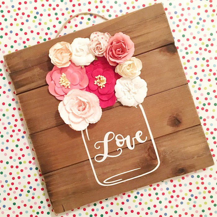Künstliche Blüten auf Holztafel, Einmachglas mit Aufschrift Liebe, Frühlingsdeko für Zuhause