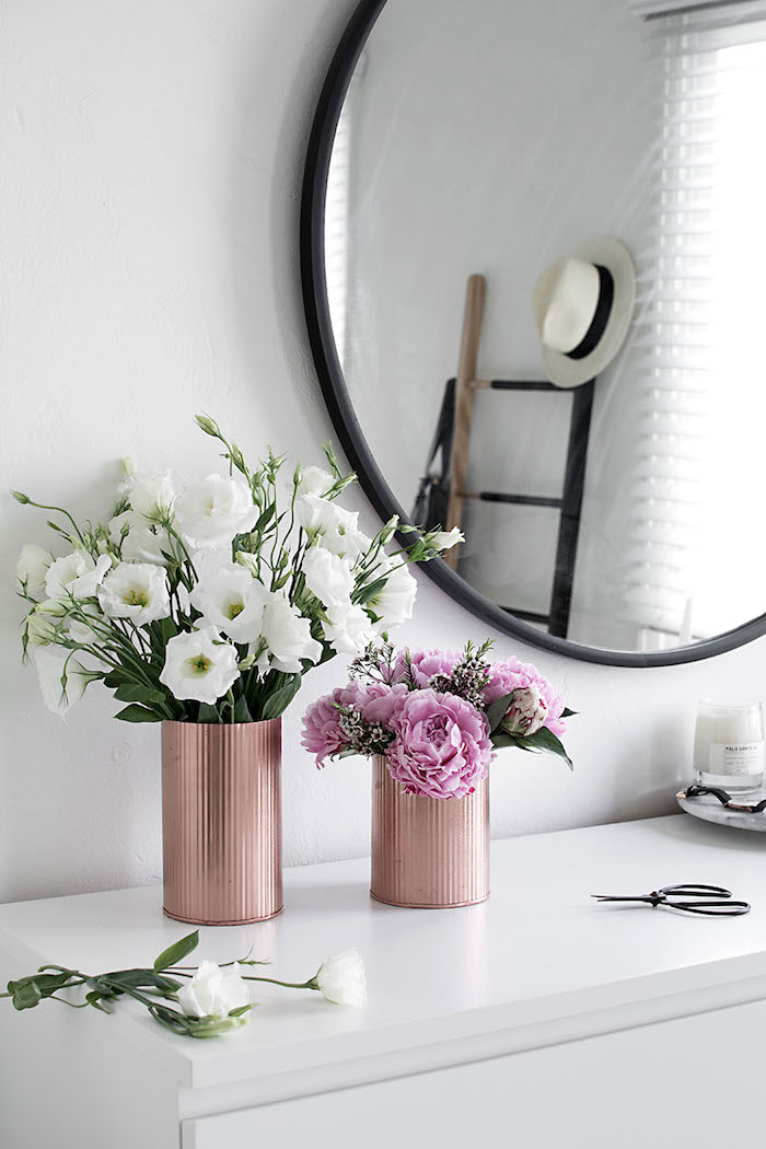 Vasen aus Dosen mit Frühlingsblumen, Deko im Schlafzimmer, weißer Schrank, Spiegel mit schwarzem Rahmen
