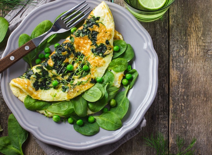 frühstücksideen gesund, ein grauer teller, omelette mit grünem salat und erbsen, viraminreich