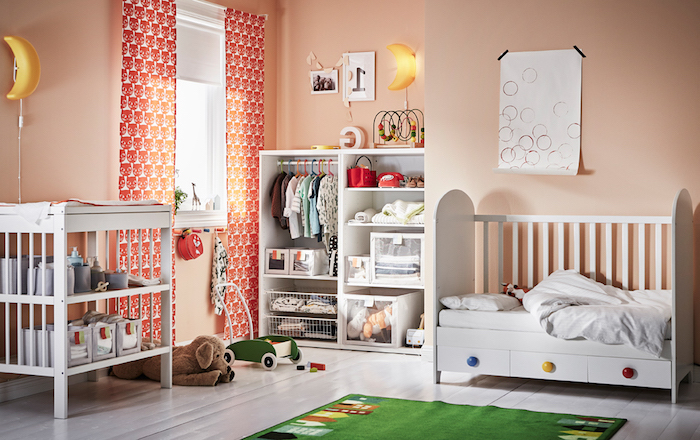 Babyzimmer in fröhlichen Farben, weiße Holzmöbel, grüner Teppich, Lampe als Mond