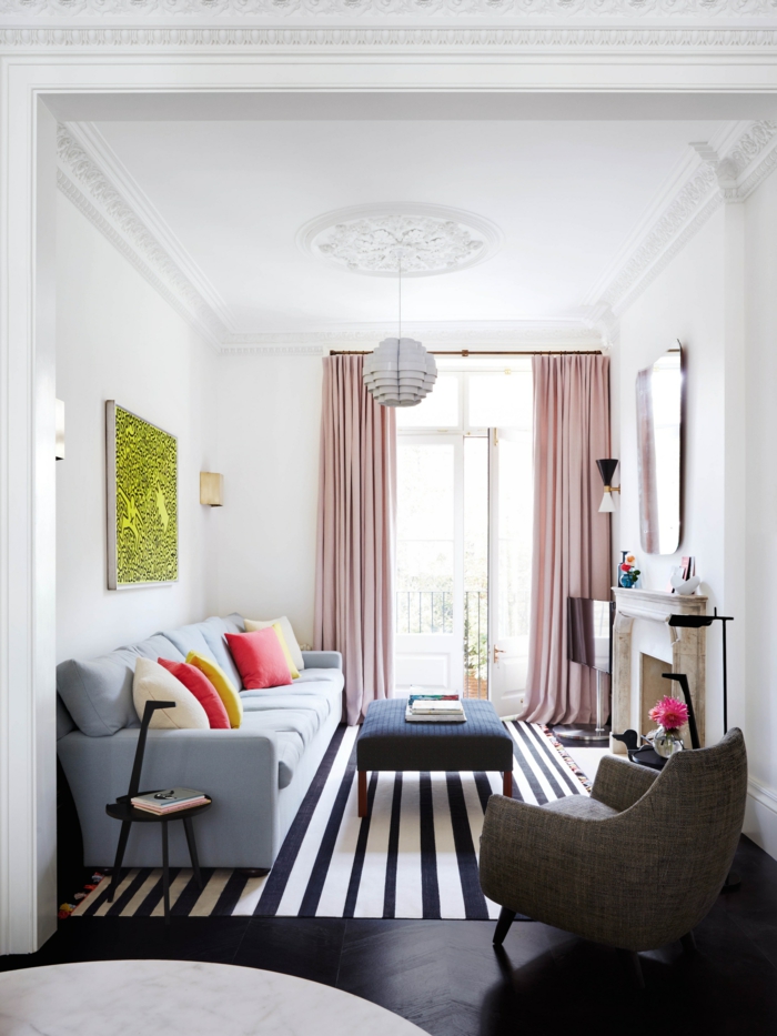 Wohnzimmer einrichten, blaue Couch, grünes Bild, rosa Vorhänge, dunkelblauer Tisch