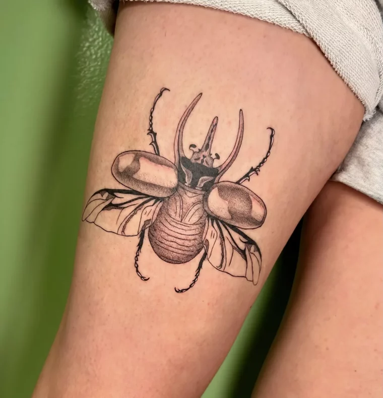 großes käfer tattoo am oberschenkel detailliert