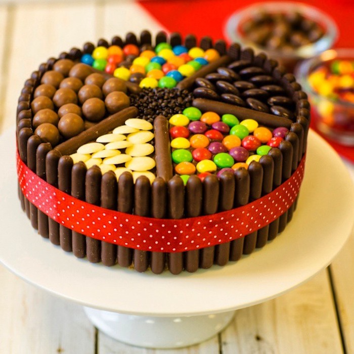 kinderschokoladen torte, rote schleife, schokoladenperlen, bunten bonbons und schkoladenriegel