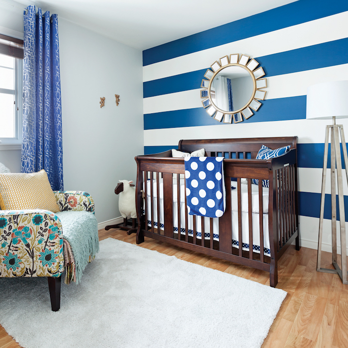 Babyzimmer für Junge in Blau und Weiß, Spiegel als Sonne, Sessel mit Blumenmuster, blaue Gardinen