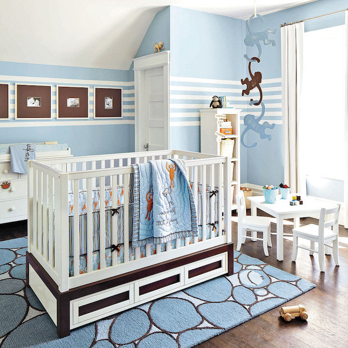 Babyzimmer in Blau, weißes Babybett, Teppich und Bettwäsche mit Affen, kleiner Tisch und Stühle