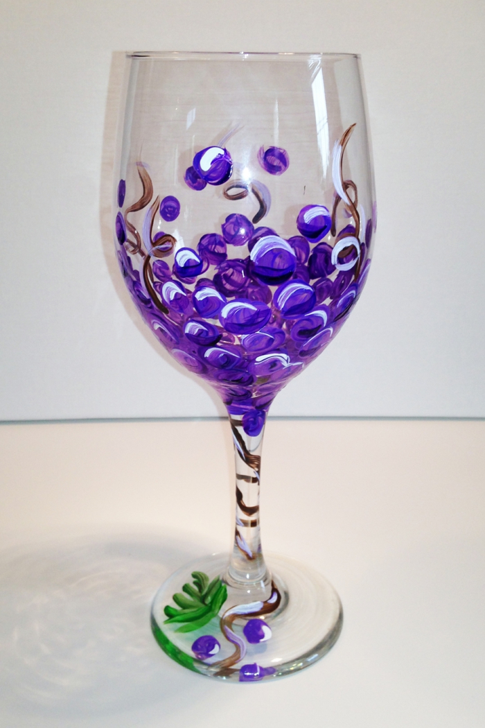 ein Weinglas mit kleinen runden Trauben in lila Farbe, Acrylfarbe auf Glas