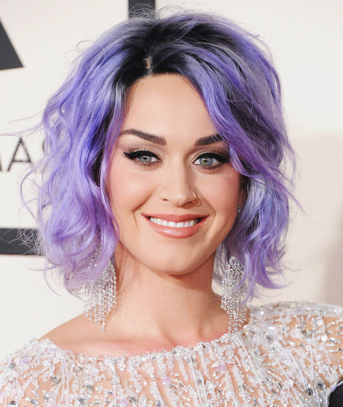 Katy Perry Bob Frisur, kinnlange lila Haare, Lidstrich und matter Lippenstift, weißes Kleid mit Kristallen